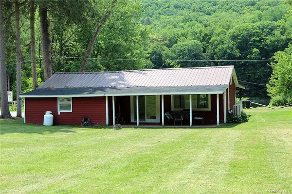 a view of a yard in front of a house with large trees
