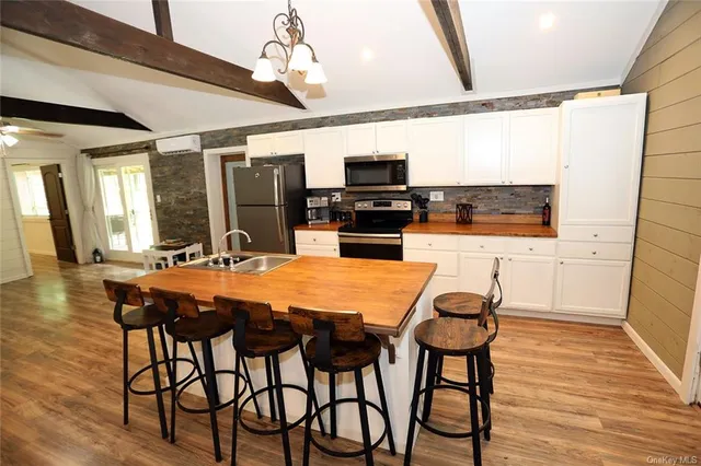a kitchen with stainless steel appliances kitchen island granite countertop a sink and cabinets