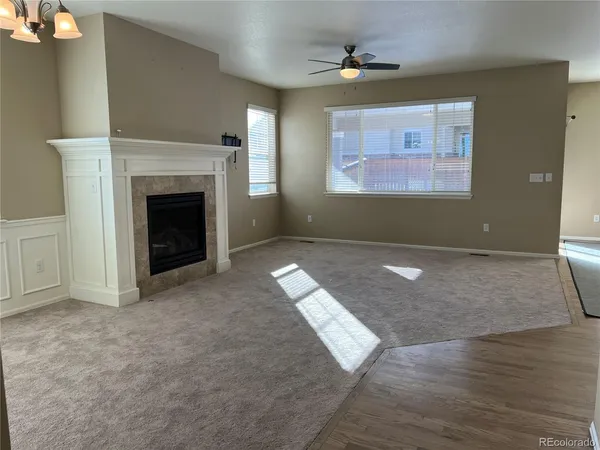 an empty room with windows and fireplace