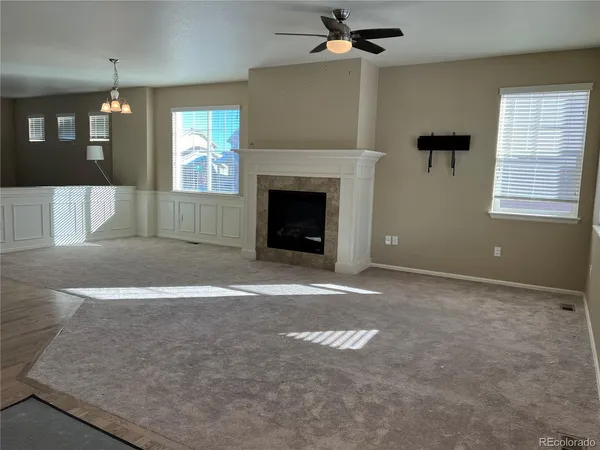 an empty room with windows and fireplace