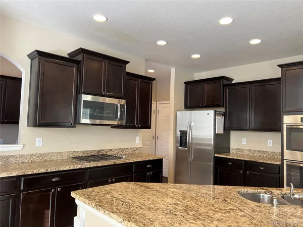 a kitchen with stainless steel appliances granite countertop refrigerator stove microwave and sink