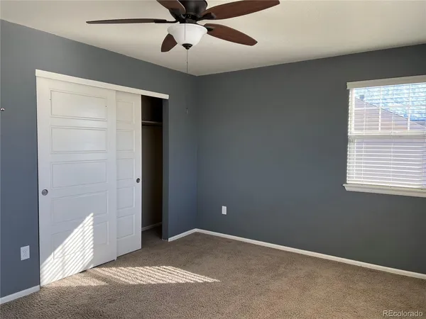 an empty room with a window and a fan