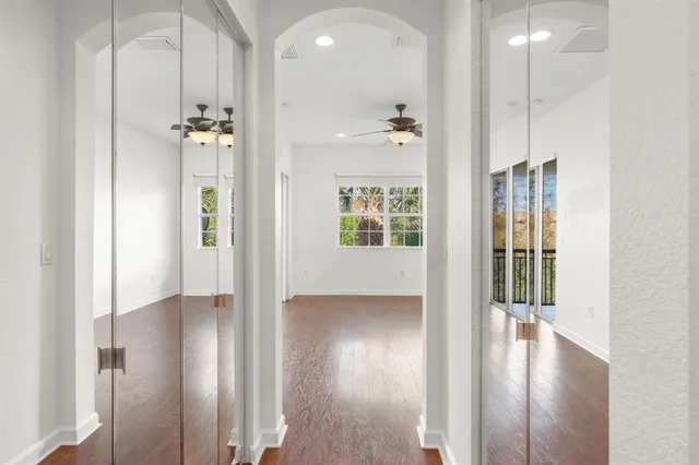 a view of a hallway with wooden floor and a bathroom