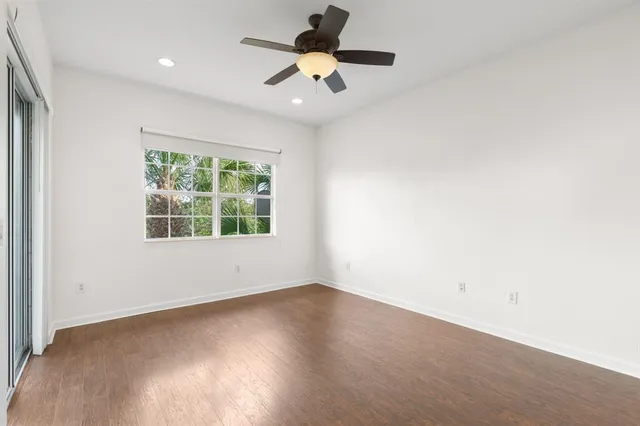 an empty room with a window and a fan