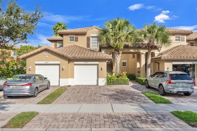 a front view of a house with a garden and parking