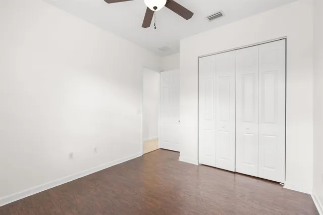 an empty room with a ceiling fan and a window