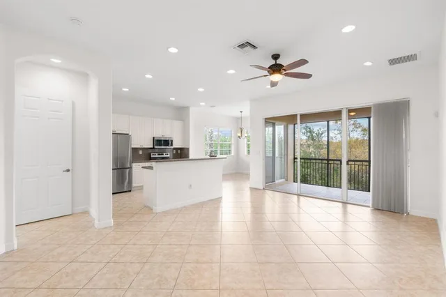 a view of a kitchen with kitchen island wooden floor and a ceiling fan