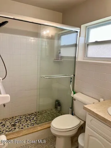 a bathroom with a toilet and a shower