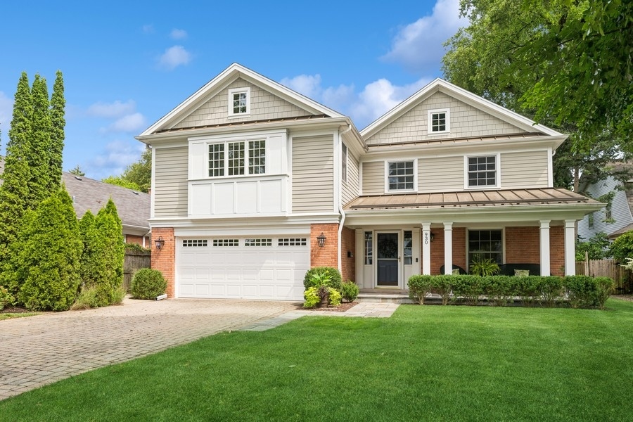 a front view of a house with a yard and green space