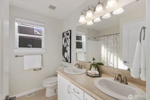 a bathroom with a granite countertop sink a toilet and a mirror
