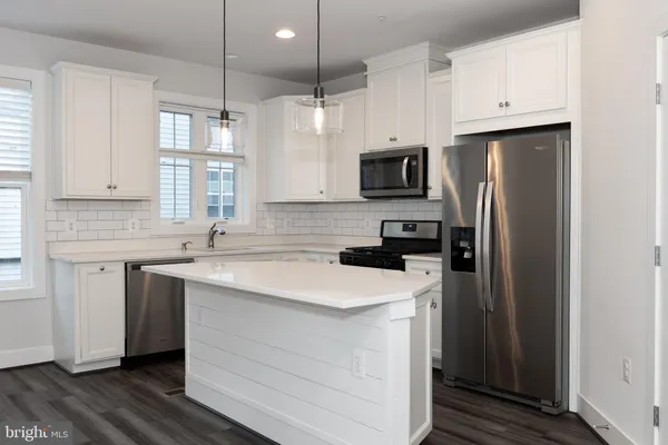 a kitchen with a sink a refrigerator a microwave and cabinets