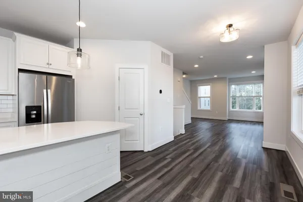a open kitchen with white cabinets and stainless steel appliances