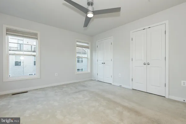 an empty room with windows and closet