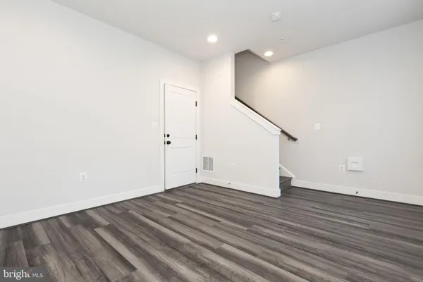 a view of an empty room with wooden floor