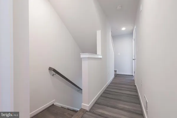 a view of a hallway with wooden floor and entryway