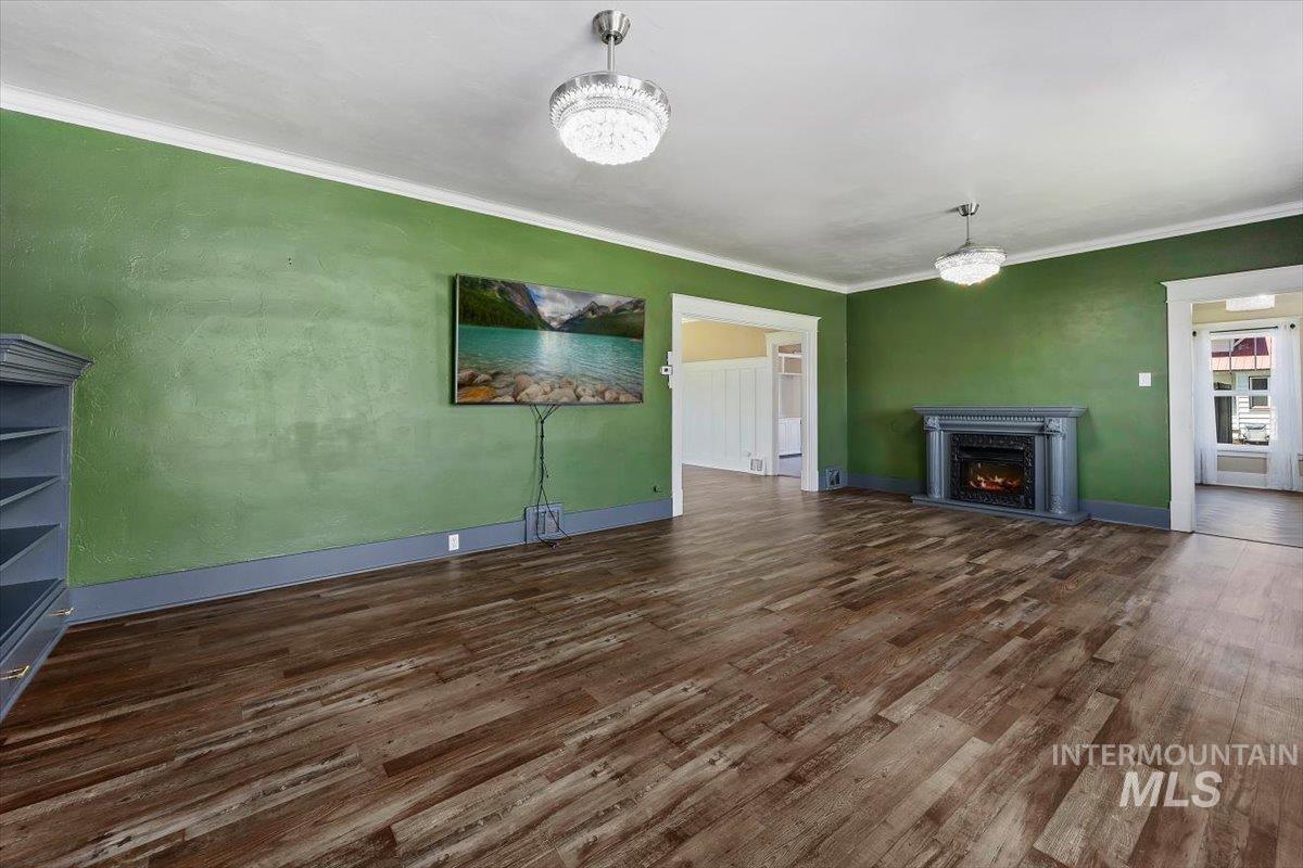 813 7th Street Rupert, ID 83350 - Photo 8 of 48 Spacious room featuring wood-finish flooring, a decorative fireplace with mantel, and recessed archways