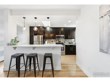 a kitchen with stainless steel appliances a table chairs refrigerator and cabinets
