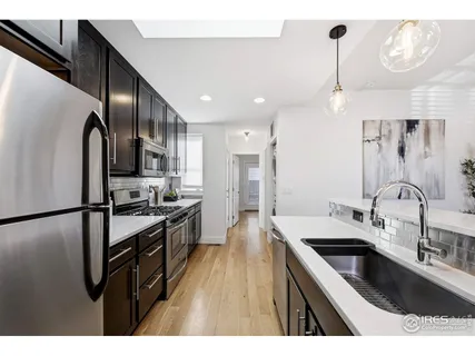 a kitchen with stainless steel appliances kitchen island granite countertop a sink refrigerator and cabinets