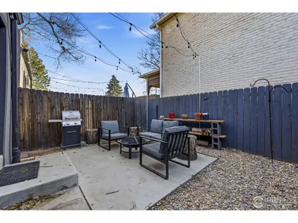 a view of a patio with table and chairs with wooden fence
