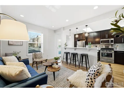 a living room with stainless steel appliances kitchen island granite countertop furniture and a large window