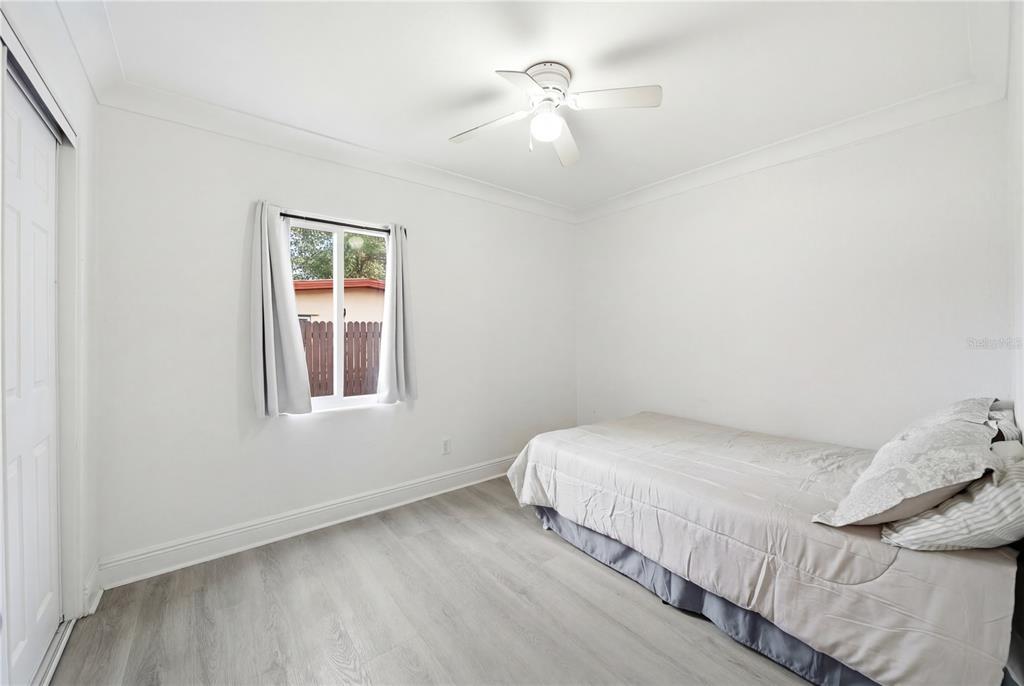 4988 Clarcona Ocoee Road Orlando, FL 32810 - Photo 21 of 48 a bedroom with a bed and a chandelier