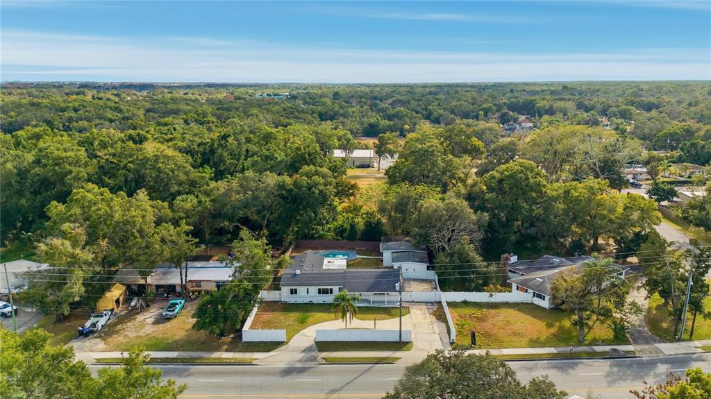 4988 Clarcona Ocoee Road Orlando, FL 32810 - Photo 46 of 48 a view of a swimming pool with seating area and trees in the background