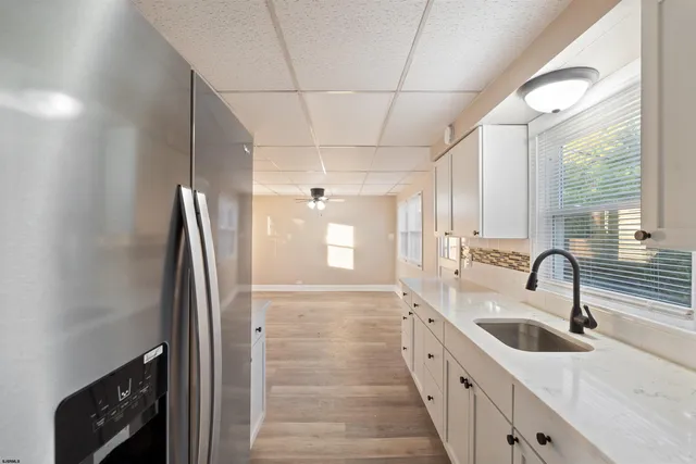 a kitchen with granite countertop white cabinets and white appliances