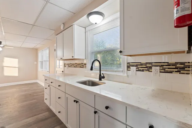 a view of a kitchen with a sink dishwasher a kitchen island with wooden floor