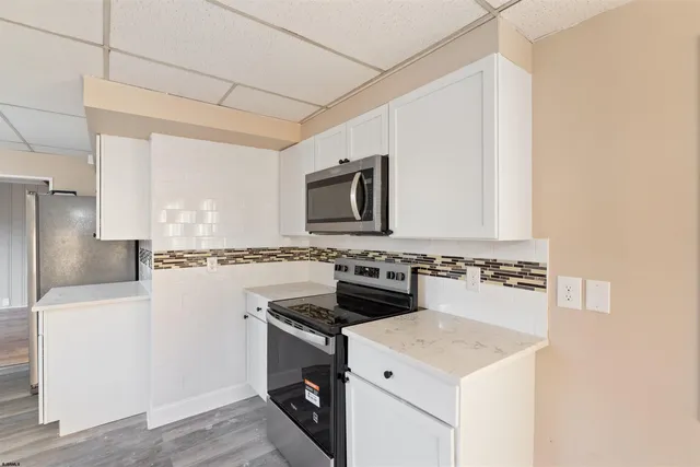 a kitchen with granite countertop a sink stove and refrigerator