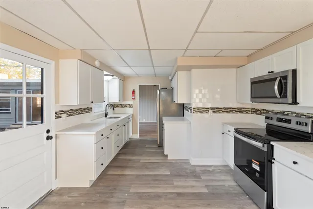 a kitchen with a stove a sink and a window