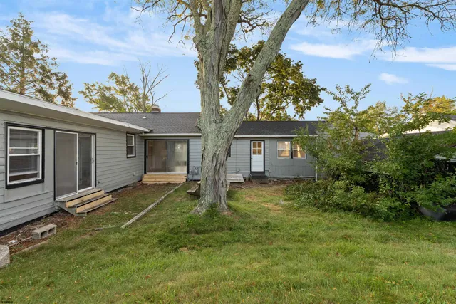 a backyard of a house with table and chairs