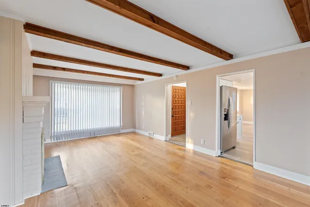 a view of empty room with wooden floor and fireplace