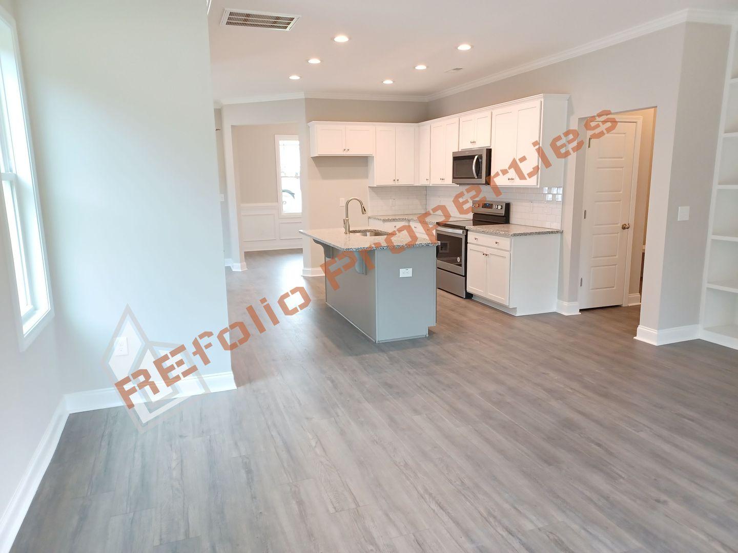 184 Howards Crossing Drive Wendell, NC 27591 - Photo 5 of 29 a kitchen with a refrigerator sink and cabinets