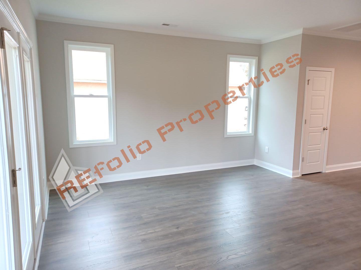 184 Howards Crossing Drive Wendell, NC 27591 - Photo 8 of 29 an empty room with wooden floor and windows