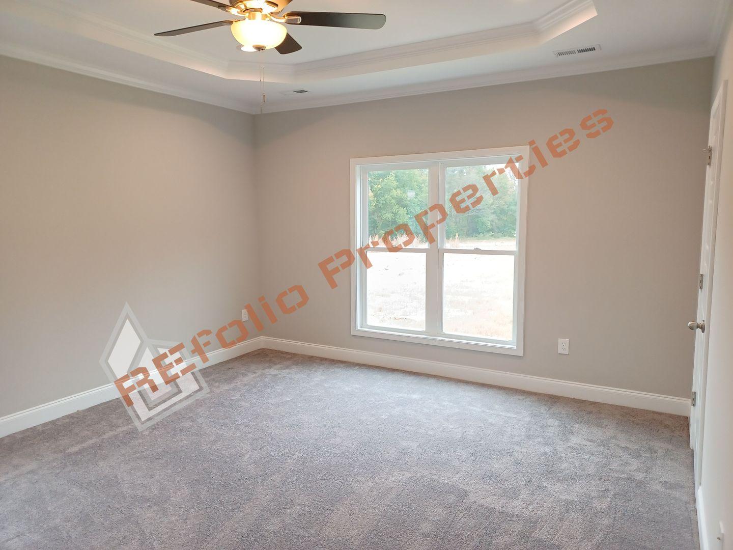 184 Howards Crossing Drive Wendell, NC 27591 - Photo 10 of 29 an empty room with windows and chandelier fan