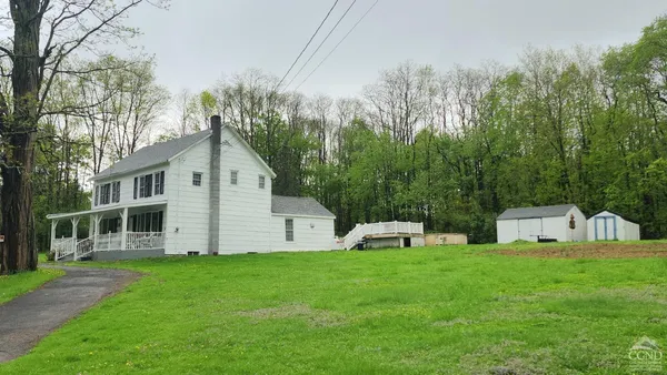 a view of a house with a yard and sitting area