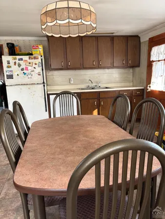 a kitchen with stainless steel appliances granite countertop a dining table chairs sink and cabinets
