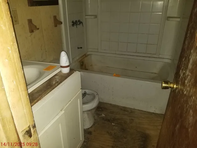 a bathroom with a granite countertop sink a toilet a tub and shower
