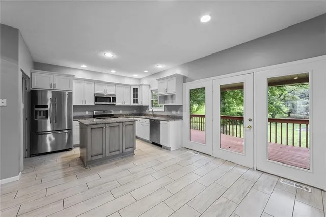 a kitchen with granite countertop a stove sink and refrigerator