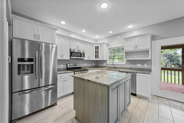 a kitchen with stainless steel appliances granite countertop wooden cabinets and a stove top oven