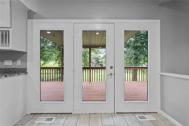 a view of an empty room with wooden floor fireplace and a window