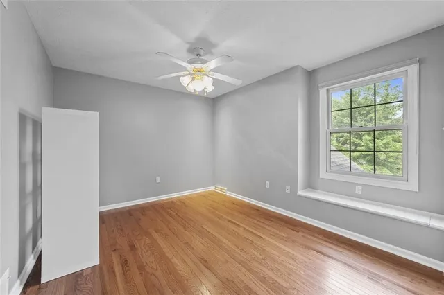 an empty room with a window and a ceiling fan