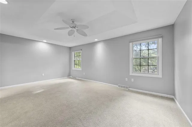 a spacious bedroom with a large bed and a chandelier