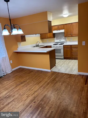 a kitchen with stainless steel appliances granite countertop a sink counter space and wooden floor