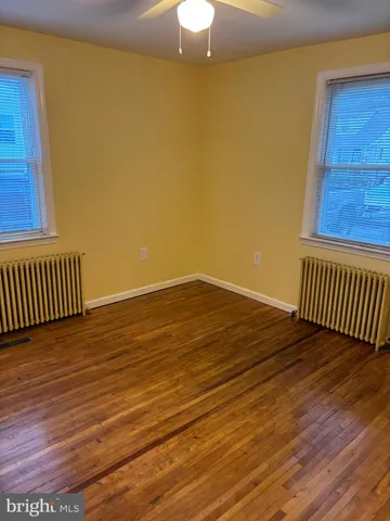 a view of a room with wooden floor and fan