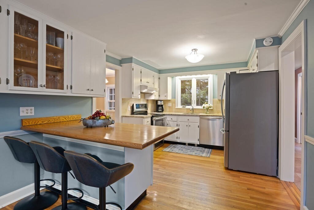 26 Virginia Road Needham, MA 02494 - Photo 11 of 41 a kitchen with stainless steel appliances granite countertop a refrigerator a sink and a stove with wooden floors