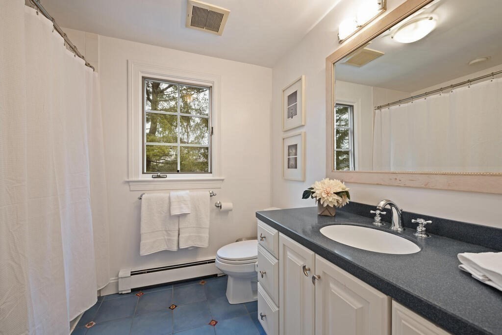 26 Virginia Road Needham, MA 02494 - Photo 22 of 41 a bathroom with a granite countertop sink toilet and a mirror