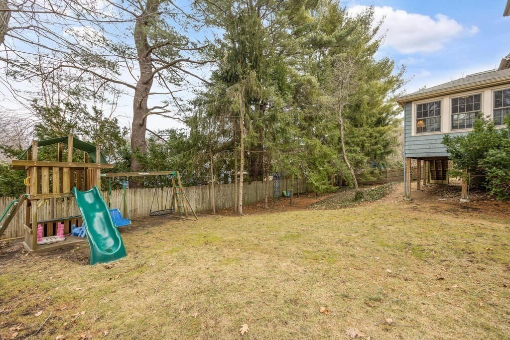 26 Virginia Road Needham, MA 02494 - Photo 39 of 41 a view of a backyard with a slide trees and wooden fence