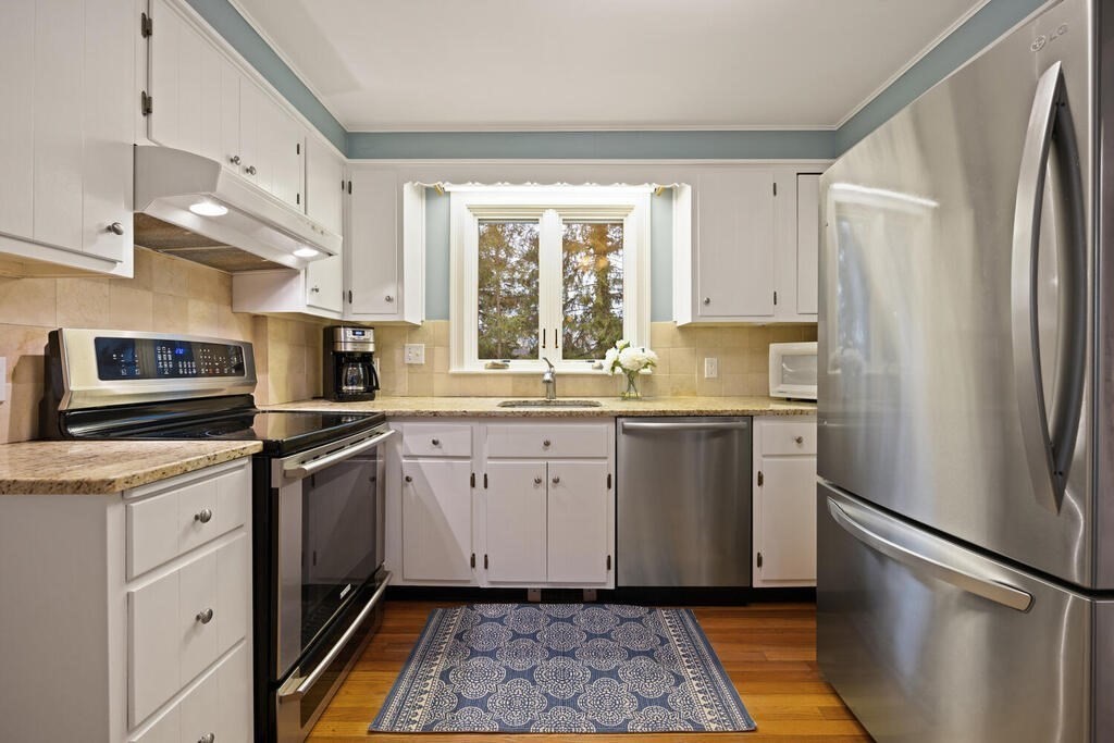 26 Virginia Road Needham, MA 02494 - Photo 10 of 41 a kitchen with granite countertop a refrigerator sink and microwave
