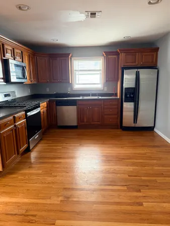 a kitchen with stainless steel appliances granite countertop a stove a sink and a refrigerator